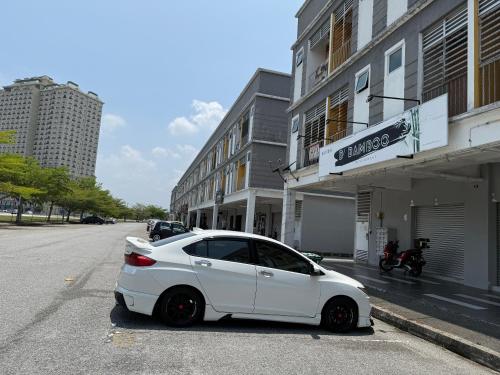 a white car parked on the side of a street at Ayden roomstay in Kampar