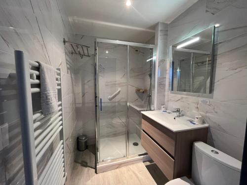 a white bathroom with a shower and a sink at Hôtel Windsor in Cannes