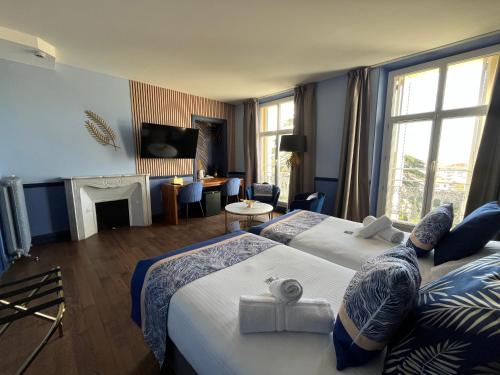 a hotel room with two beds and a fireplace at Hôtel Windsor in Cannes