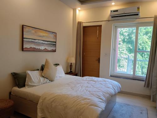 a bedroom with a large bed and a window at Pennylane Hotel - Aesthetic Rooms with pottery studio, artshala, garden cafe, free airport pickup for 7 or more nights bookings in Rishīkesh
