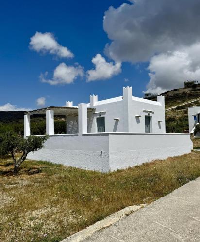 a white house on the side of a road at Iosub Houses & Studios - Beach House in Koumbara in Tzamaria