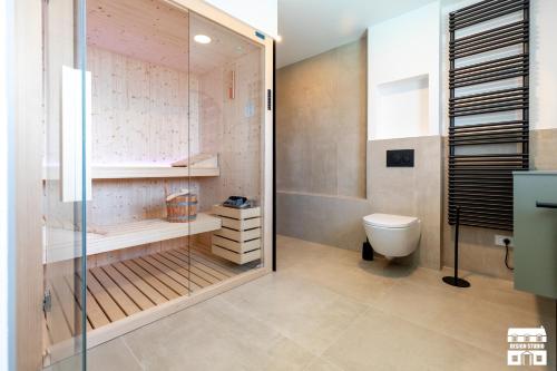 a bathroom with a toilet and a glass shower at APPARTAMENTO BELAGO by Design Studio in Bellano