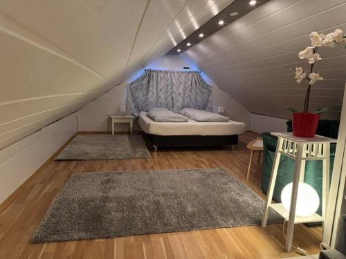 a attic room with a couch and a table at Apartment Bjarmaland in Vestmannaeyjar