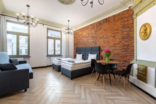 a living room with two beds and a brick wall at Pod Błękitnymi Podkowami in Wrocław