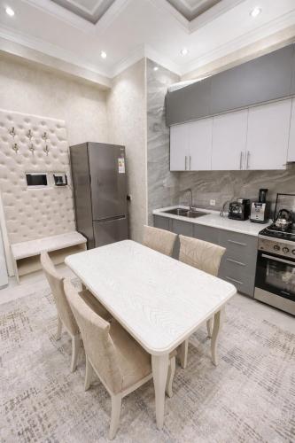 a kitchen with a white table and chairs in it at Boulevard 2BR Luxury Apartment in Tashkent