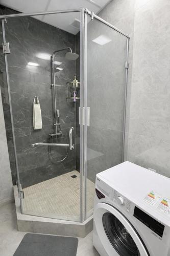 a shower with a washing machine in a bathroom at Boulevard 2BR Luxury Apartment in Tashkent