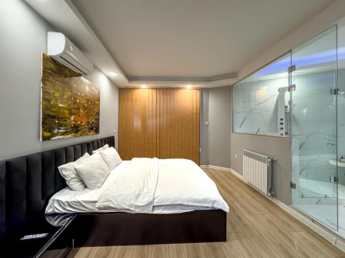 a bedroom with a bed and a glass wall at Amelia Terrace Escape in Tbilisi City