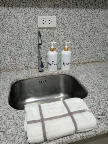 a kitchen sink with two towels and a faucet at Sweet Escape 22 at O Residences in Bacolod