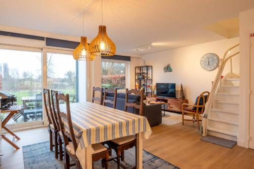 a dining room and living room with a table and chairs at Fully equipped holiday home for 6 in Nieuwpoort