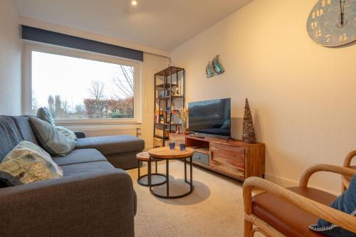 a living room with a couch and a television at Fully equipped holiday home for 6 in Nieuwpoort