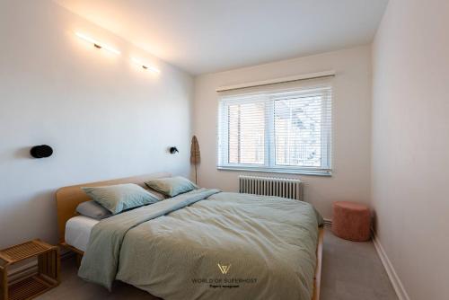 a bedroom with a bed and a window at Luxurious apartment next to the sea and city centre with free parking space in Ostend