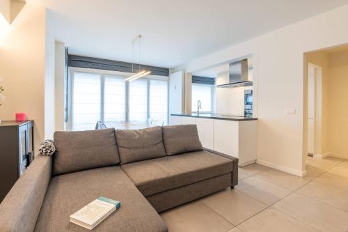 a living room with a couch and a kitchen at Amazing apartment for 8 with parking space in Ostend