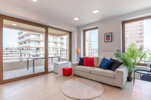 a living room with a couch and large windows at Perfectly situated condo with amazing views in Ostend