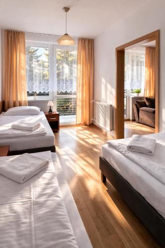 a hotel room with two beds and a mirror at Hotel Olimpik Park in Słubice