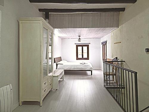 a white room with a bed and a staircase at CAL MA Ponts in Ponst