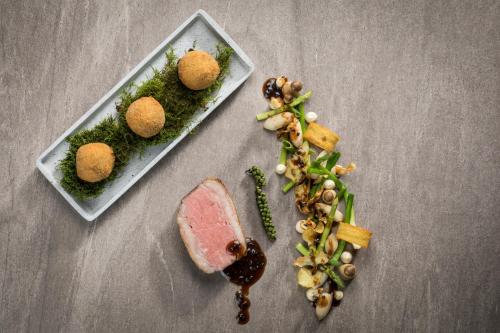 two plates of food with meat and vegetables on a table at Minglers Sportalm - Das Gourmet- und Genießerhotel in Kirchberg in Tirol