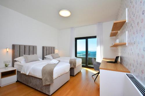 a bedroom with two beds and a desk with a laptop at Moderna villa "Split na dlanu" s grijanim bazenom in Klis