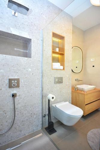 a bathroom with a shower and a toilet and a sink at Moderna villa "Split na dlanu" s grijanim bazenom in Klis