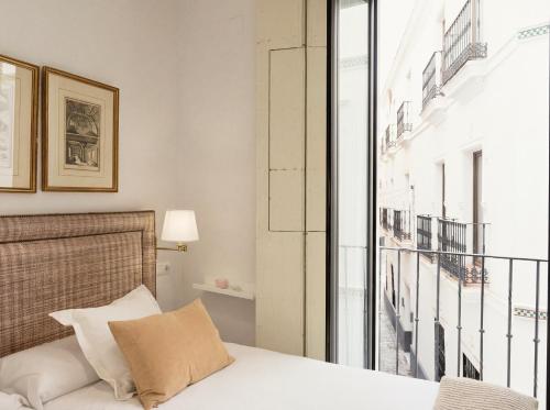 a bedroom with a bed and a large window at Sevilla Home Center in Seville