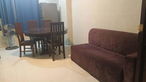 a living room with a couch and a table and chairs at RnR Suites in Dagupan
