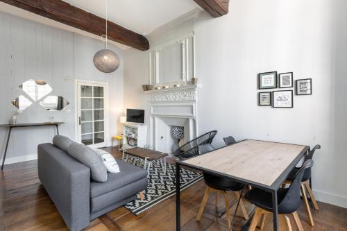 un salon avec une table et un canapé dans l'établissement Ty Sauveur by Cocoonr, à Rennes