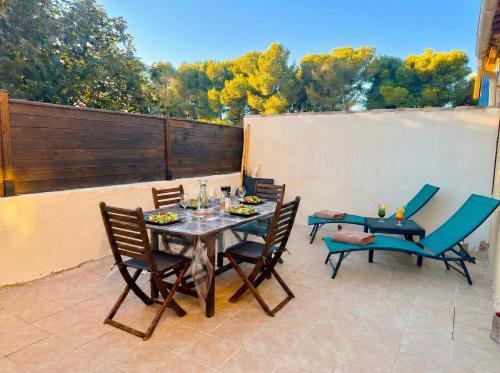 a patio with a table and chairs and a fence at Cozy & elegant, proche de Martigues in Saint-Mitre-les-Remparts