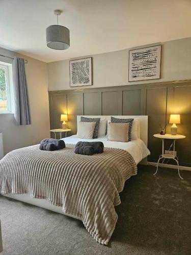 a bedroom with a large bed with two pillows on it at Cosy Bungalow in the Peak in Glossop