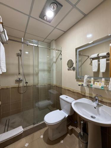 a bathroom with a toilet and a shower and a sink at Hotel Grand Samarkand Superior - B in Samarkand