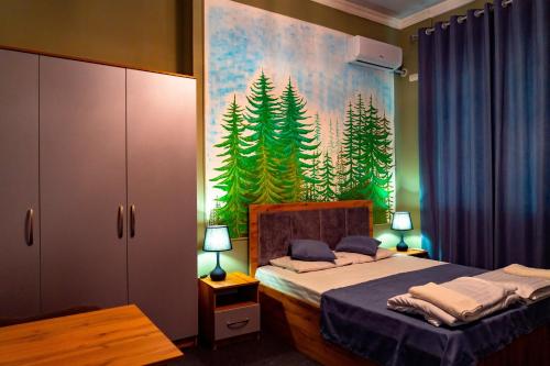 a bedroom with a bed with a painting on the wall at Light Hostel by TripLE in Yakkasaray