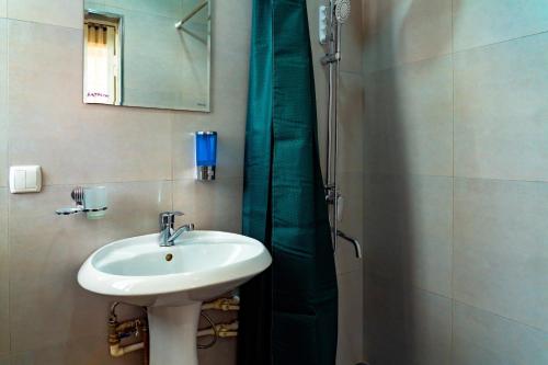 a bathroom with a sink and a shower at Light Hostel by TripLE in Yakkasaray