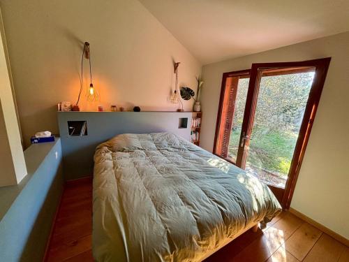 a bedroom with a bed and a large window at Exceptional house with a pool in Jarrie