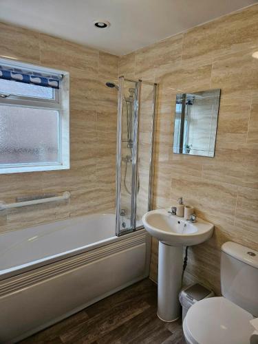 a bathroom with a sink and a tub and a toilet at Cosy Bungalow in the Peak in Glossop