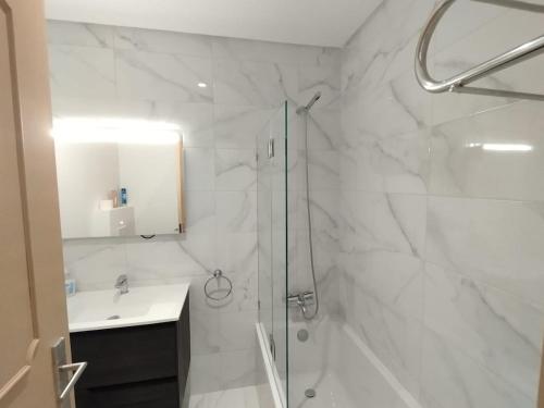 a white bathroom with a shower and a sink at Casa Santos Faro Beach in FAO