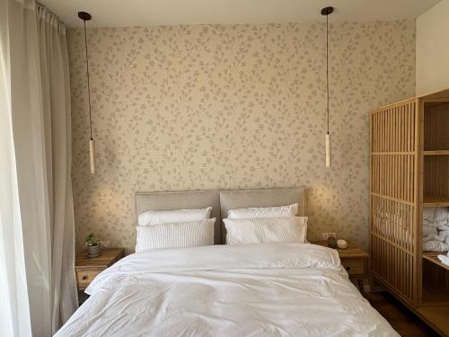 a bedroom with a white bed with two pillows at בקצה הוואדי - The Wadi Edge in Yeroẖam