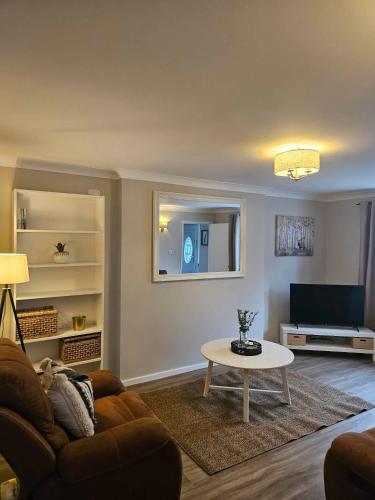 a living room with a couch and a table at Cosy Bungalow in the Peak in Glossop