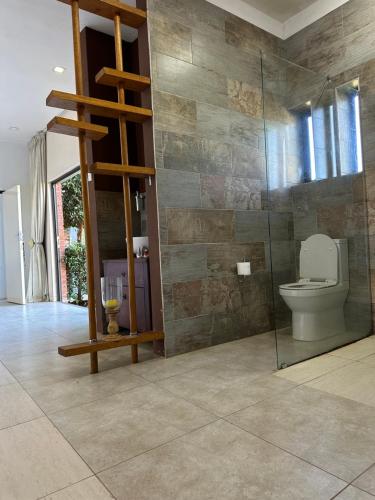a bathroom with a toilet and a glass wall at At TheSoil in Edendale