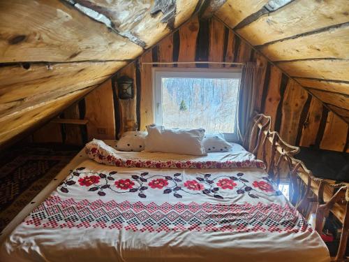a bed in a wooden room with a window at Casa rustica in Braşov