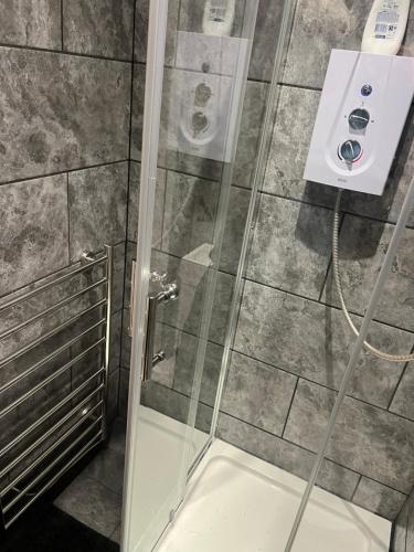 a shower with a glass door in a bathroom at The Little Hexthorpe house in Doncaster