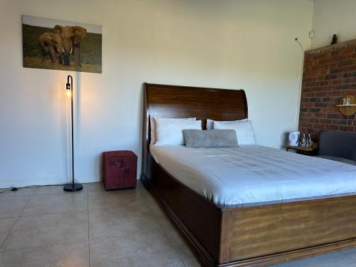 a bedroom with a bed and a lamp in it at At TheSoil in Edendale