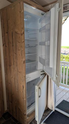 a refrigerator with its door open next to a porch at M6 Mallard Rise in Goodrington