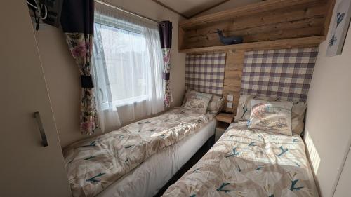 a bedroom with two beds and a window at M6 Mallard Rise in Goodrington