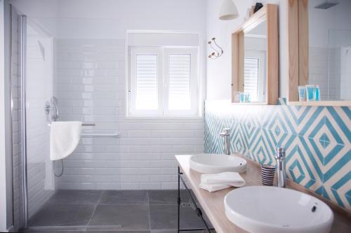 a bathroom with two sinks and a shower at Hostal La Casa Sanlúcar in Sanlúcar de Barrameda