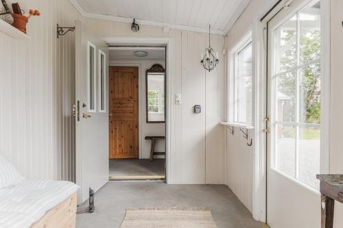 a hallway with a door leading into a room with a window at Rustic Nordic Getaway by the Sea in Axmar