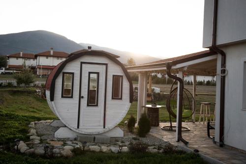 a tiny house sitting on top of a yard at Къща за гости В 12 и 5 in Dolna Banya