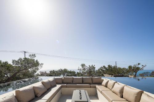 eine Terrasse mit Sofa und Swimmingpool in der Unterkunft Seanatra Luxury Villas in Ferma