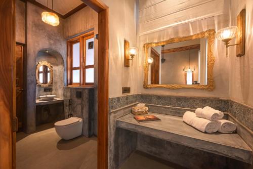 a bathroom with a sink and a toilet and a mirror at Anjuna Casa Nova in Jāmb