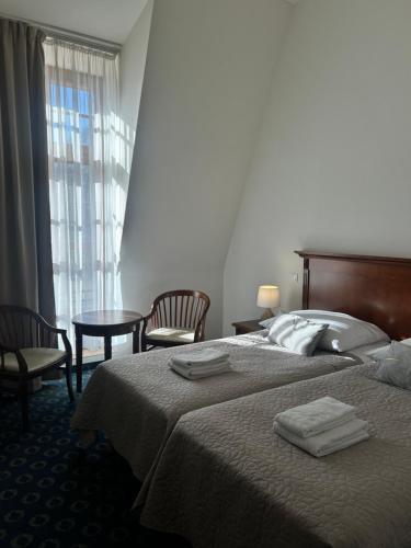 a hotel room with a bed and two chairs and a table at Pałac w Rymaniu in Rymań