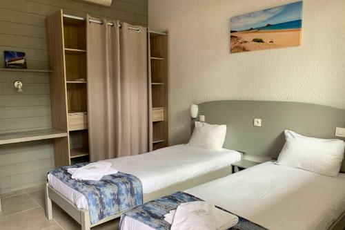 a room with two beds and a closet at Camping les Criques de Royan in Saint-Georges-de-Didonne
