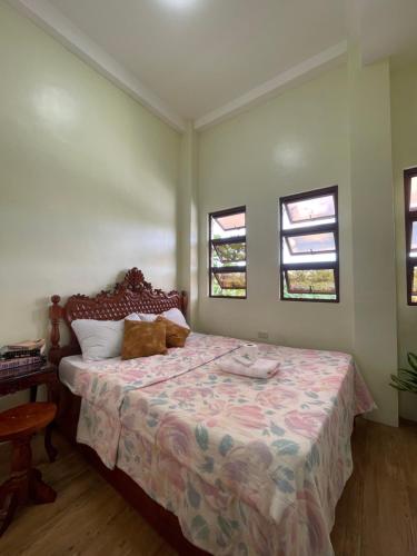 a bedroom with a bed and two windows at B2-B Guesthouse in Guiuan