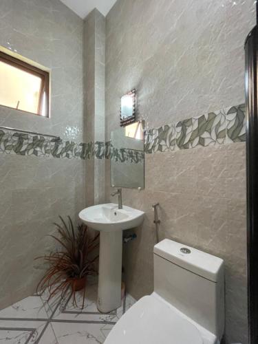 a bathroom with a white toilet and a sink at B2-B Guesthouse in Guiuan